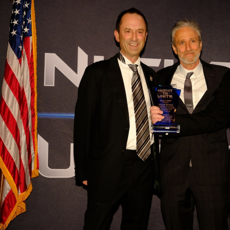 A photo of Michael Barasch and Jon Stewart.